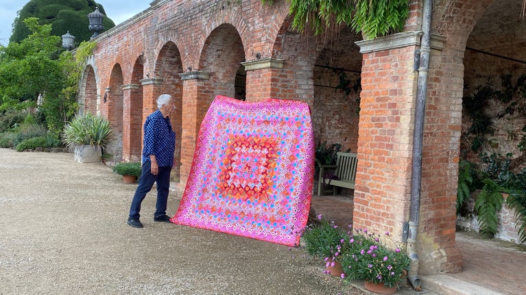 Kaffe Fassett gyda chwilt â swigod yn yr ardd yng Nghastell Powis, Cymru